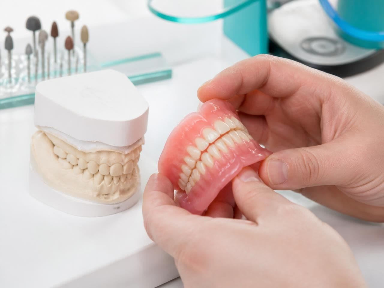 A finished complete denture next to its plaster model